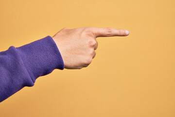 Wall Mural - Hand of caucasian young man showing fingers over isolated yellow background pointing with index finger to the side, suggesting and selecting a choice