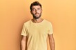 © Krakenimages.com - Handsome man with beard wearing casual yellow tshirt over yellow background relaxed with serious expression on face. simple and natural looking at the camera.
