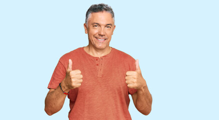 Poster - Handsome middle age man wearing casual clothes success sign doing positive gesture with hand, thumbs up smiling and happy. cheerful expression and winner gesture.