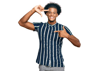 African american man with afro hair wearing casual clothes smiling making frame with hands and fingers with happy face. creativity and photography concept.