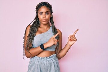 Sticker - Young african american woman with braids wearing sports clothes skeptic and nervous, frowning upset because of problem. negative person.