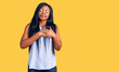 © Krakenimages.com - Young african american woman wearing casual clothes smiling with hands on chest with closed eyes and grateful gesture on face. health concept.