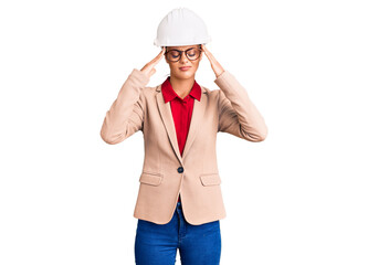 Sticker - Young beautiful woman wearing architect hardhat suffering from headache desperate and stressed because pain and migraine. hands on head.