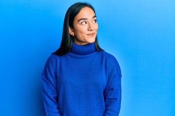 Canvas Print - Young asian woman wearing casual winter sweater smiling looking to the side and staring away thinking.