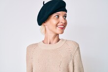 Young Blonde Woman Wearing French Look With Beret Looking Away To Side With Smile On Face, Natural Expression. Laughing Confident.