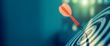 bullseye target or dart board has red dart arrow throw hitting the center of a shooting for business targeting and winning goals business concepts.