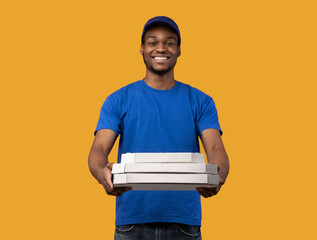 Wall Mural - Black delivery man holding pizza boxes, giving it to camera