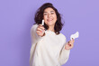 © sementsova321 - Photo of attractive Caucasian woman holds cotton tampon and sanitary napkin, has happy look, monthly menstrual cycle, wears white sweater. Protective care for women health.