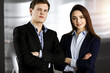 © rogerphoto - Friendly young colleagues are standing as a team with crossed arms in sunny office. Successful business people at work