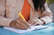 © Oleksii - Closeup shot of university student hand holding pen, writing in notebook, studying, learning language, exam preparation,  education concept. Business woman taking notes, working project at workplace