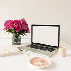 Wall Mural - Office desk table workspace with blank copy space mock up laptop screen. Modern stylish home interior design with pink peonies flower bouquet. Blog, social media, website hero template.