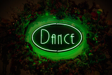 Green neon dance sign against dark background