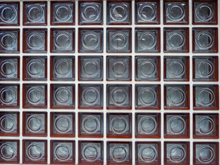 Poster - Background from a wall with glass tiles. A mosaic of glass squares in the wall. Square glass plates in the architecture. Glassy wall texture. Texture of a building side.