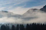 Fototapeta Na ścianę - Brg im Nebel vor blauem Himmel udn Wolken mit 