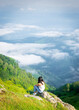 © Evaldas - Woman sits in nature above the clouds and enjoy nature panorama. Georgia travel pristine nature