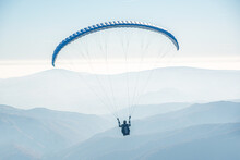 The Paraglider Is Flying In The Sky.