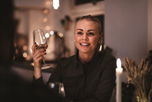 Smiling Woman Talking With Another Guest During A Dinner Party