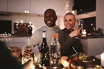 Couple laughing over wine with friends at a dinner party