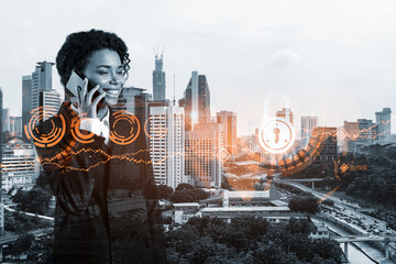 Wall Mural - Attractive black businesswoman developer having conference call to protect clients confidential information by inventing solutions. IT lock icons over Kuala Lumpur city background.