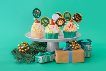 Wall Mural - Dessert stand with tasty Christmas cupcakes on color background