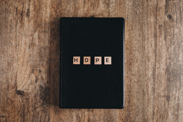 Wall Mural - Hope in block letters on a bible on a wooden table.Top view flat lay.