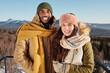 © pressmaster - Happy young intercultural dates in winterwear standing against sky and mounts