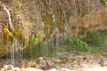 Water Flowing From The Rock To Alpine Stream