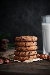 Chocolate cookies with glass of milk on wooden table.