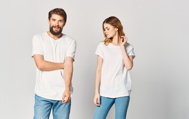 a man and a woman in jeans and a T-shirt on a light background gesturing with hands portrait friends family