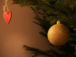 Christmas decoration background, with a ball and a heart hanging on a fir branch