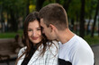 © somemeans - Portrait of beautiful young couple in park. Guy gently touches the girls cheek with his nose.