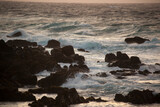 Fototapeta Pomosty - Ocean crashing onto a rocky shore at sunset