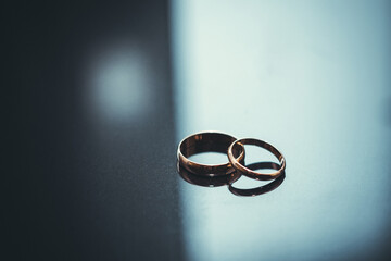 two traditional wedding gold engagement rings lie