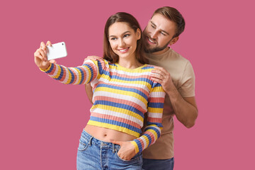 Canvas Print - Young couple taking selfie on color background