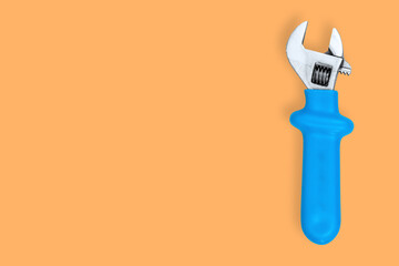 Wrench on an orange background. Seamless background from adjustable metal wrench.