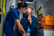 © Anna Kosolapova - Injured Man sitting with an oxygen mask in an ambulance car, a young nurse is holding his hand.