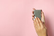 Female hands hold handmade soap on pink background