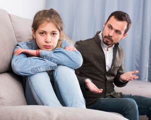 Young father quarrelling with his daughter teenager at home