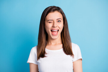 photo of tricky funny young lady wear white clothes winking open mouth isolated blue color backgroun