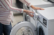 © zinkevych - Close up picture of womans hands examining a washing machine
