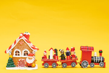 Sticker - toy christmas house with santa claus train on a yellow background