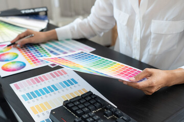 Poster - creative graphic designer choosing color scale for editing artwork while working in office.