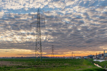 An Industrial Area Crossed By The High Voltage Line Under A Dramatic Sky Just Before Sunset