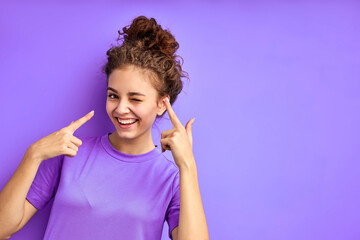 cute joydul cheerful girl have fun posing isolated in studio with purple background, attractive emotional female in shirt look at camera