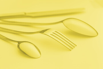 Cutlery set on background, colored in yellow.