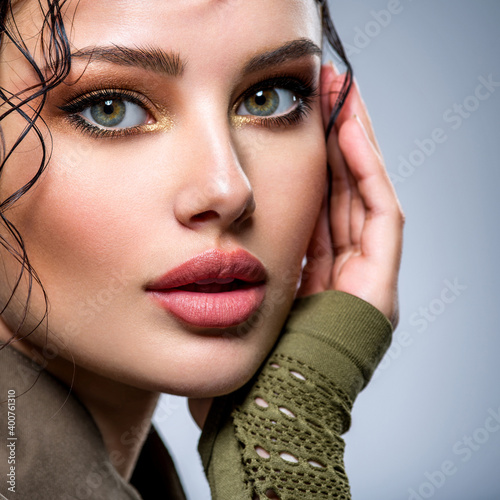 Closeup portrait of a beautiful young fashion woman with brown makeup posing at studio Billede på lærred