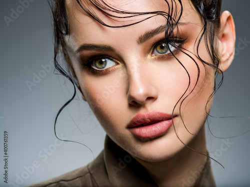 Closeup portrait of a beautiful young fashion woman with glamour makeup posing at studio Fototapet