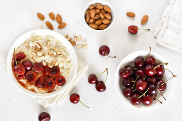 Wall Mural - Oatmeal porridge with cherry slices and nuts in bowl