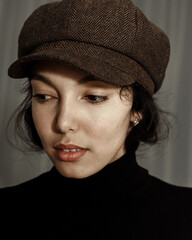 Wall Mural - Portrait of beautiful brunette young woman in hat looking at camera.