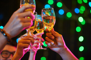 Poster - Cropped image of young people toasting with glasses of champagne when celebrating New Year in night club